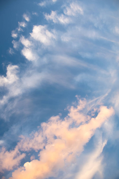 Morning sky with colorful clouds. Blue background of white and gold or yellow clouds. Vertical photo - Photo, Image