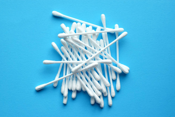Lots of plastic cotton swabs on a blue background.  - 写真・画像
