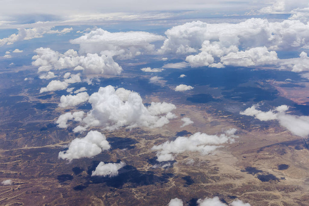 Landschaftliche Landschaft der Gebirgswüste New Mexico mit klaren, flauschigen Wolken das Gebirge aus dem Flugzeug in den USA - Foto, Bild