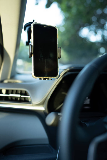 Teléfono montado en un parabrisas de un coche en el campo de visión de los conductores - Foto, Imagen