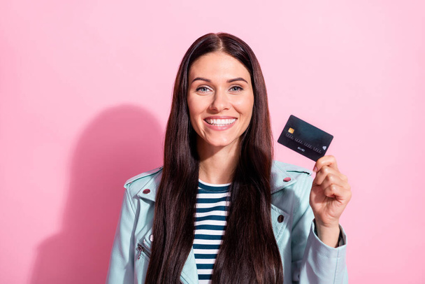 Photo of charming happy young woman hold credit card good mood isolated on pastel pink color background - Фото, изображение