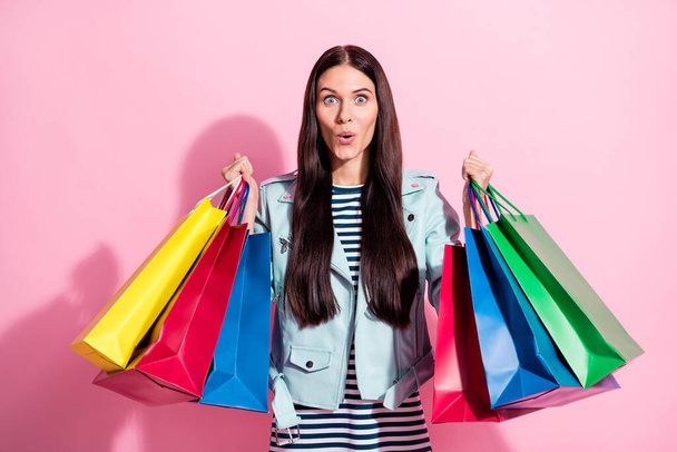 Photo of astonished nice cute young woman amazed shopping sale hold bags isolated on pink color background - Zdjęcie, obraz
