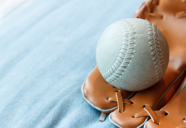 бейсбол в рукавичці на синьому ліжку
 - Фото, зображення
