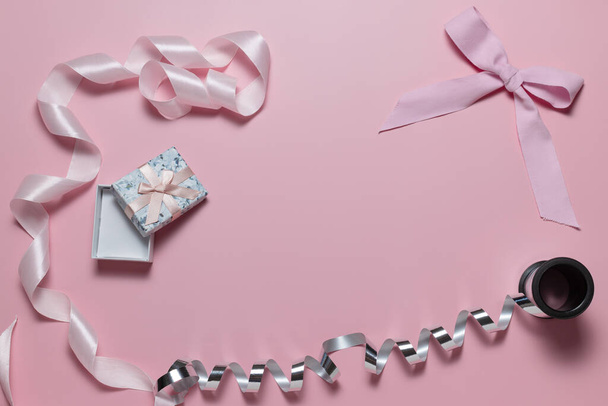 ピンクの背景にギフト包装のための弓、ピンクとシルバーリボン付きの小さなギフトボックス - 写真・画像
