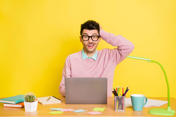 Photo of young man clueless confused no answer study online laptop isolated over yellow color background - Φωτογραφία, εικόνα