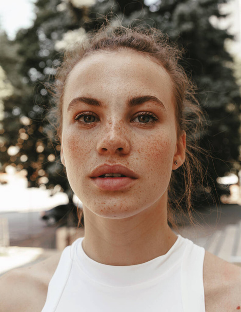 Portrait of a beautiful and cute girl with freckles in the street - Foto, Imagem
