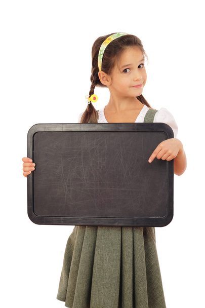 Little schoolgirl pointing to empty chalkboard, isolated on white - Valokuva, kuva