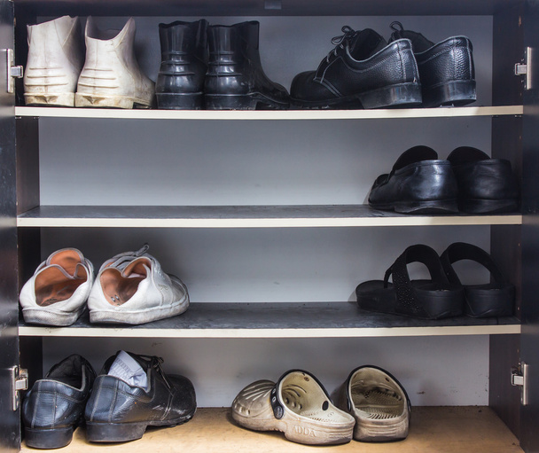 Schuhe, Turnschuhe, Stiefel und andere Schuhe stehen auf einem Regal  - Foto, Bild