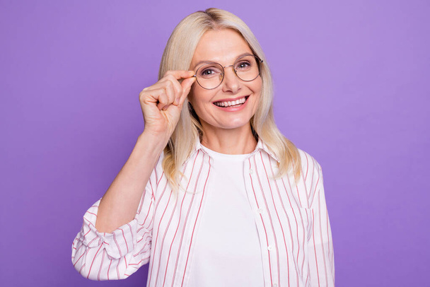 Photo of sweet shiny mature woman dressed pink shirt arm eyewear isolated purple color background - Foto, afbeelding