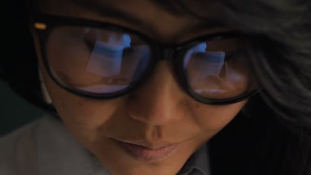 Nuori nainen käyttää silmälaseja heijastaen kirjan sivuja lähikuva - Materiaali, video