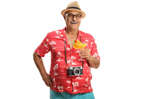 Happy mature male tourist with camera around his neck holding a cocktail isolated on white background - Photo, image