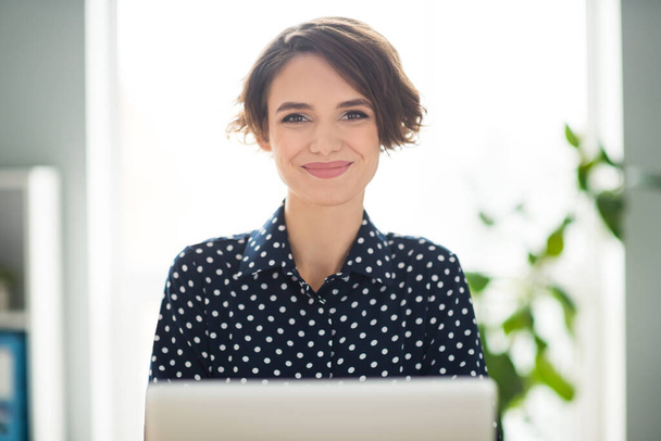 Photo portrait of cheerful female worker sitting on computer wearing dotted shirt smiling in office - Fotografie, Obrázek