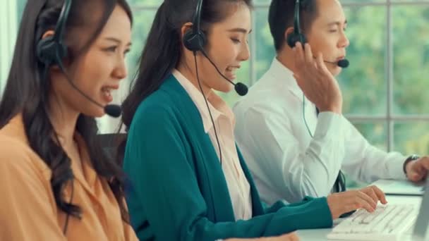 Gente de negocios que usa auriculares trabajando activamente en la oficina - Metraje, vídeo