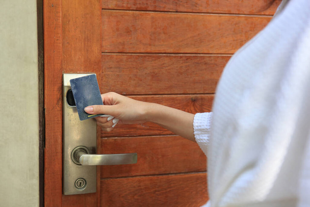 femme porte ouverte avec carte-clé, gros plan des mains de femme de ménage tenant la carte et ouvrant la porte de la chambre d'hôtel - Photo, image