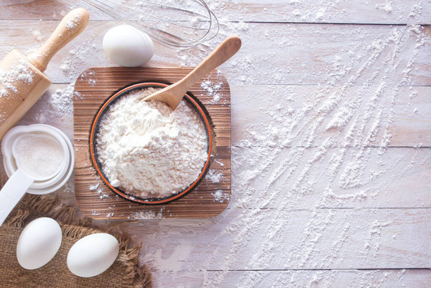 Домашние рецепты муки (яйца, мука, сахар) и скалка на деревянном столе, вид сверху - Фото, изображение