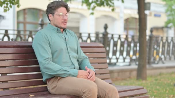 Hombre que tiene dolor de espalda mientras está sentado en el banco  - Metraje, vídeo