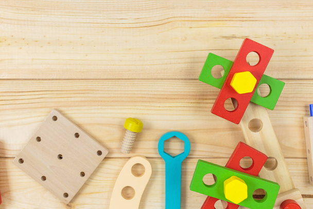 Um kit de construção de madeira colorido para crianças em madeira. Conjunto de ferramentas em mesa de madeira. Jogos e ferramentas para crianças em pré-escola ou creche. Brinquedos naturais e ecológicos. - Foto, Imagem