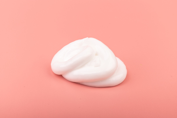 ホワイト美容クリームローションハイライトスミアスウォッチスマッジオンピンク桃の背景 - 写真・画像