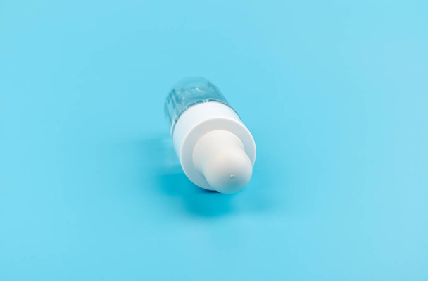 Cosmetic or medical glass bottle with pipette on blue background, in close-up. Skin care concept.  - Фото, зображення