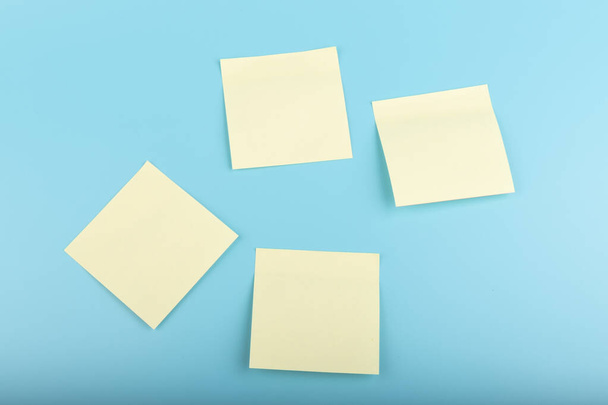 blank square yellow reminder paper notes on blue texture background.  - Foto, Imagen