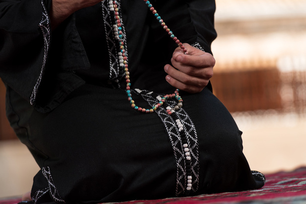 Close-up van mannelijke handen bidden met rozenkrans - Foto, afbeelding