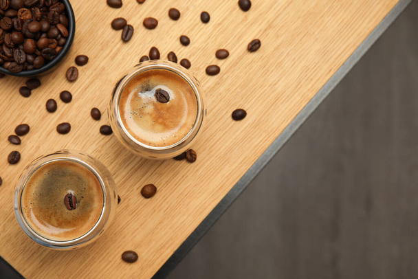 Tasty coffee and beans on wooden table, flat lay. Space for text - Fotoğraf, Görsel