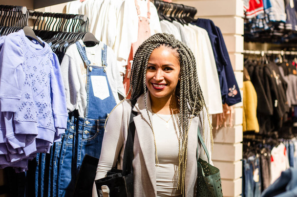 Femme péruvienne souriant avec des tresses faisant du shopping pour des vêtements. - Photo, image
