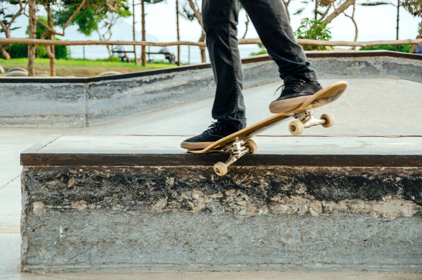 Skateboarder is doing a crooked grind trick on a bench in skatepark. - Photo, image