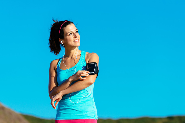 Sporty woman with smartphone armband and earphones - Valokuva, kuva