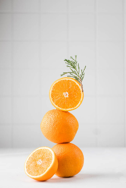 Still life balance of oranges and a branch of fir. The concept of winter, New Year and Christmas. Copy space. - Foto, immagini