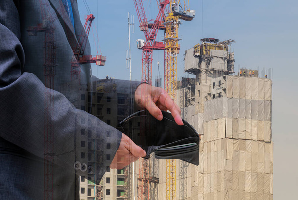 Geschäftsleute überprüfen schwarze Brieftasche auf Bauhintergrund, Geschäftskonzept - Foto, Bild