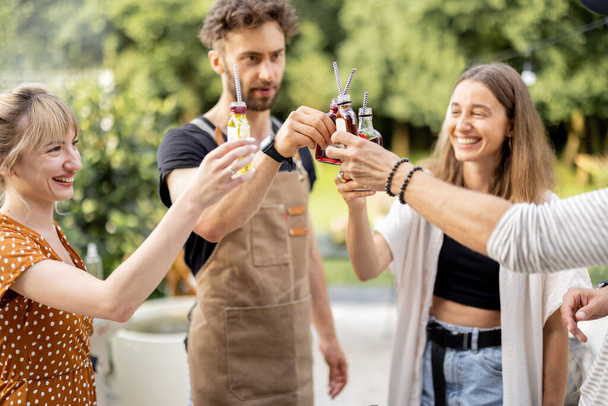 Amigos con alcohol en un picnic en el patio trasero - Foto, Imagen