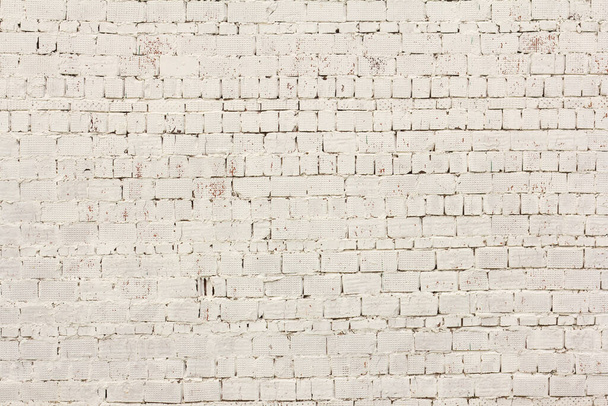 Bílá cihlová stěna.Cihlové pozadí.Cihlová zeď staré budovy je natřená na bílo - Fotografie, Obrázek