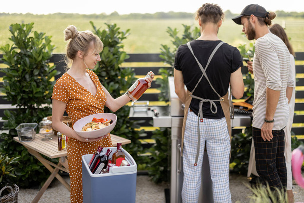 Друзья с едой и алкоголем на заднем дворе на пикнике - Фото, изображение