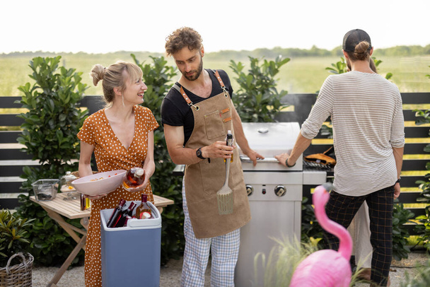Друзья с едой и алкоголем на заднем дворе на пикнике - Фото, изображение