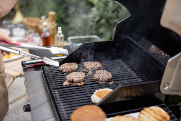 Grilling burgers on a grill outdoors - Φωτογραφία, εικόνα
