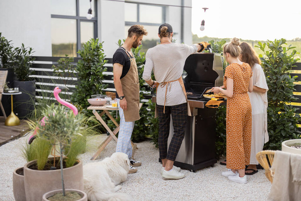Young people grilling food at backyard - Zdjęcie, obraz