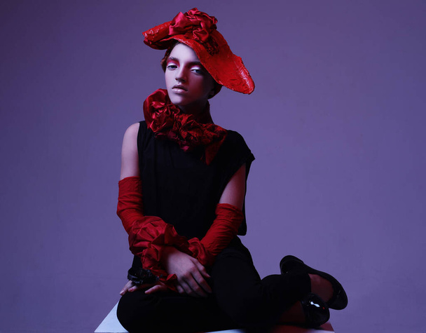Beautiful child girl in a stylish fashionable suit - red hat, scarf, bracelet, neon light, fashion concept - 写真・画像