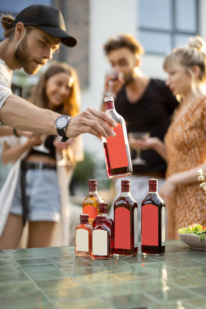 Mladí lidé slaví s alkoholem na dvorku - Fotografie, Obrázek