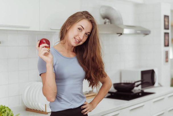 Healthy woman holding vegetables in kitchen. Happy Young woman showing fruits and vegetables for cooking healthy food. - Photo, image