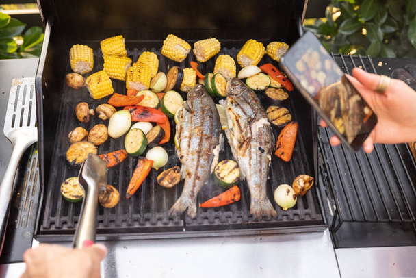 Grilling fish and corn on a grill - Foto, afbeelding
