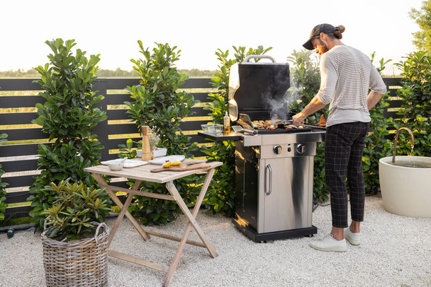Mężczyzna gotowanie na grillu na zewnątrz - Zdjęcie, obraz