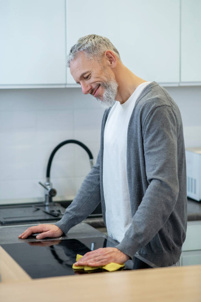 Man in homewear washing the plates in the kitchen - Fotografie, Obrázek