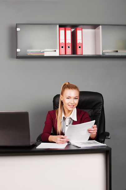 Beautiful businesswoman sitting  in office and looking at camera - Fotoğraf, Görsel