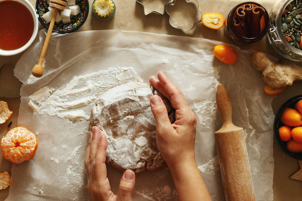 Женщина делает домашнее пряничное печенье на Рождество, подготовка к празднику, вид сверху. - Фото, изображение