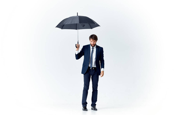 homem de negócios em um terno segurando um guarda-chuva estilo elegante proteção contra a chuva - Foto, Imagem