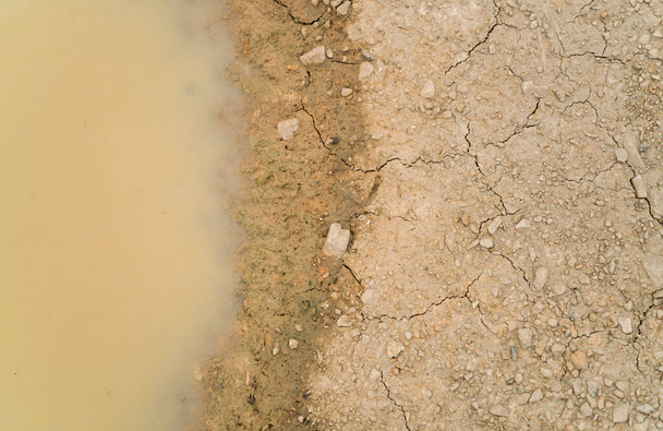 Water puddle on dirty soil ground. - Photo, Image