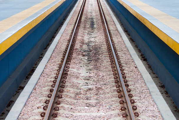 Lange en rechte lijn spoorrails in het midden van foto. - Foto, afbeelding