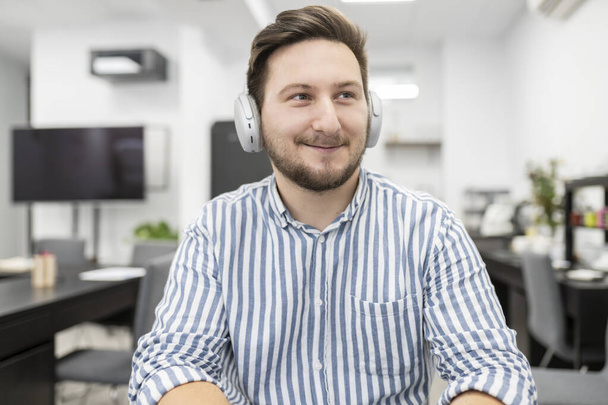 man with headphones in office working happy smiling - Photo, Image