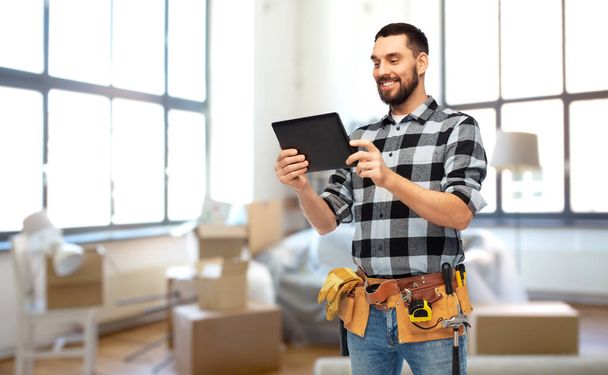 happy builder with tablet pc and tools at home - Φωτογραφία, εικόνα
